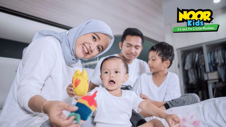 A Muslim family of four plays together to make Islam for kids fun, the mother and baby smiling at the camera holding toys.